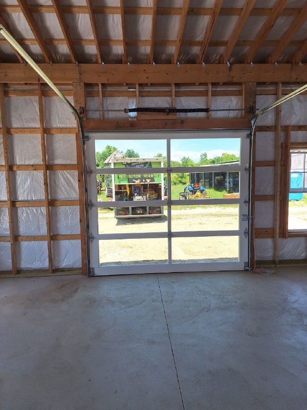 A man installing or repairing siding on a house, holding a screwdriver.